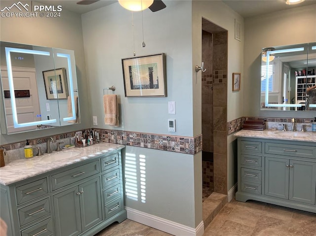 bathroom with a tile shower, ceiling fan, and vanity