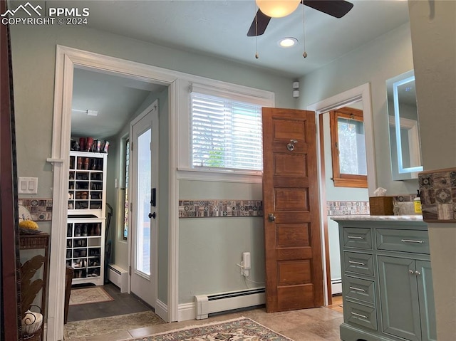 bathroom featuring tile patterned flooring, vanity, ceiling fan, and a baseboard heating unit