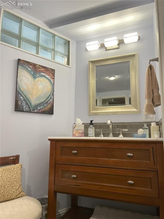 bathroom featuring beamed ceiling and vanity