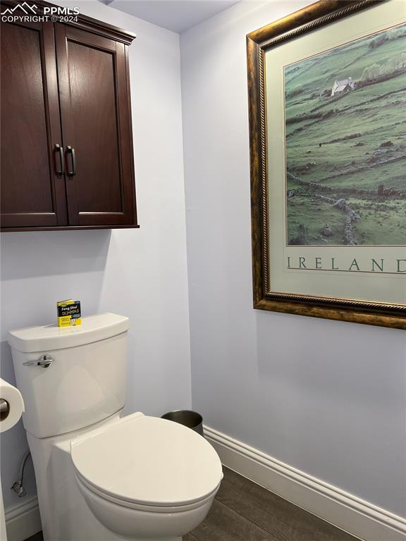 822 Willow St, Trinidad, CO 81082 - half bath with toilet, baseboards, and wood finished floors