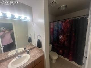 bathroom with tile patterned flooring, vanity, and toilet