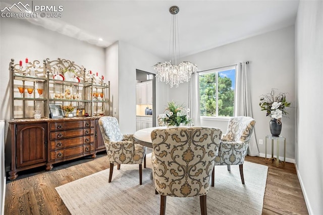 dining space with light hardwood / wood-style floors and a chandelier