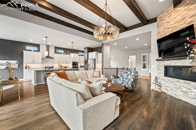 living room featuring a fireplace, beamed ceiling, dark hardwood / wood-style floors, and an inviting chandelier