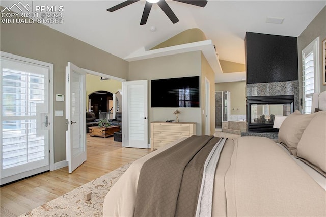 bedroom with multiple windows, ceiling fan, light hardwood / wood-style flooring, and vaulted ceiling