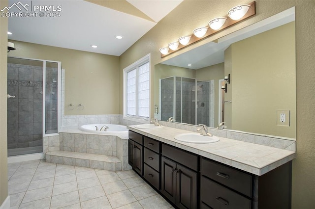 bathroom featuring tile patterned flooring, vanity, and shower with separate bathtub