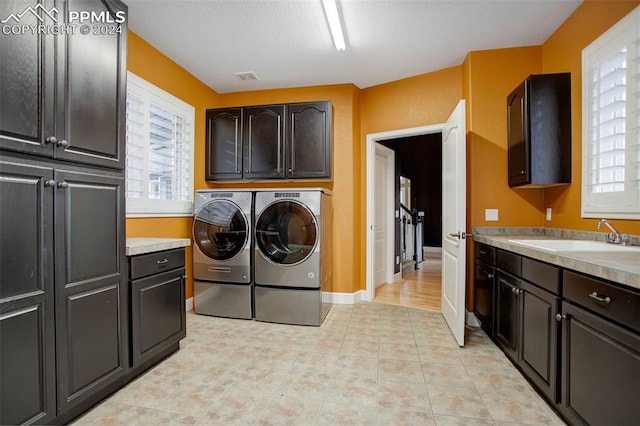 laundry room with cabinets, separate washer and dryer, and sink