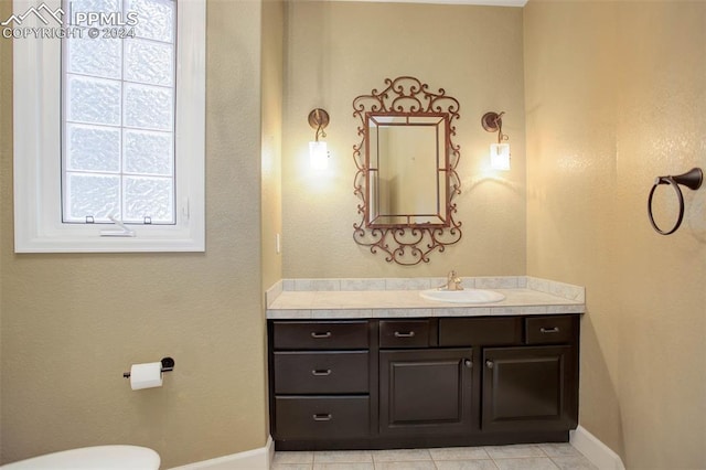 bathroom with tile patterned flooring, vanity, and toilet