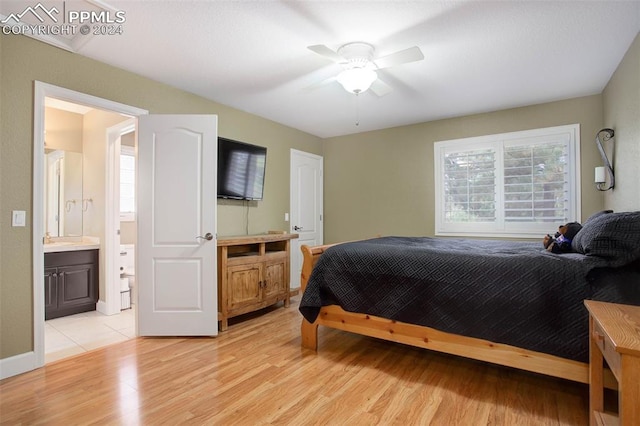 bedroom with ensuite bath, ceiling fan, and light hardwood / wood-style floors