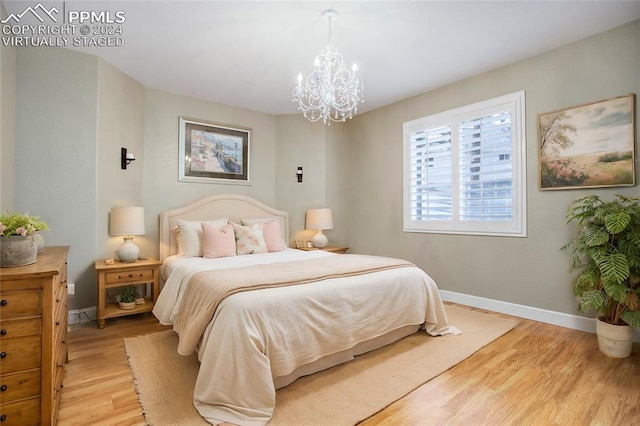 bedroom featuring a notable chandelier and light wood-type flooring