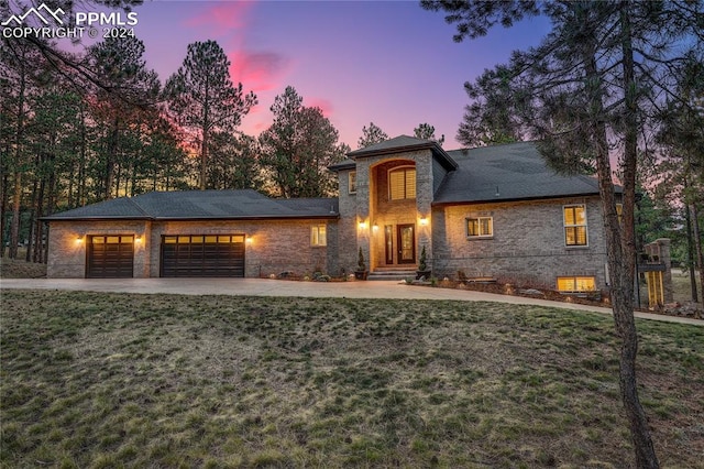 view of front of home with a garage and a yard