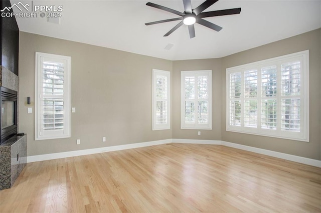 unfurnished living room with light wood-type flooring, ceiling fan, and a healthy amount of sunlight