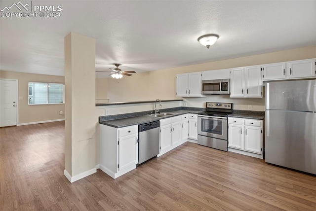 kitchen featuring light wood-type flooring, white cabinetry, sink, and appliances with stainless steel finishes