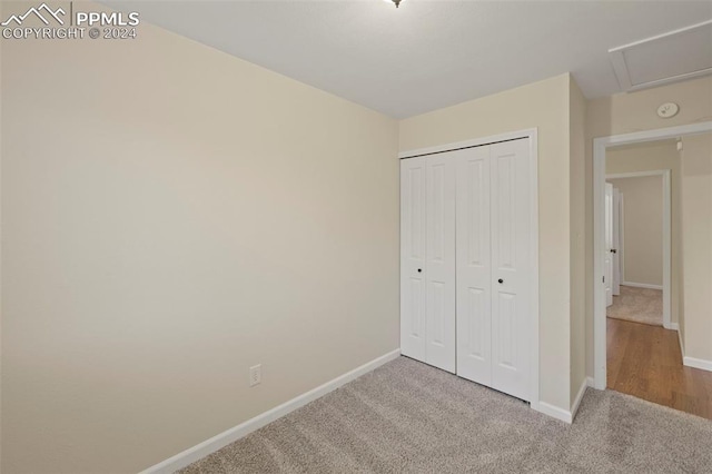 unfurnished bedroom featuring light colored carpet and a closet