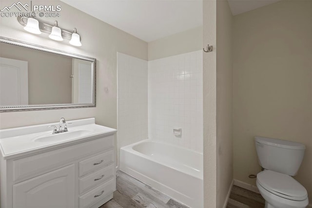 full bathroom featuring hardwood / wood-style floors, vanity, toilet, and shower / tub combination