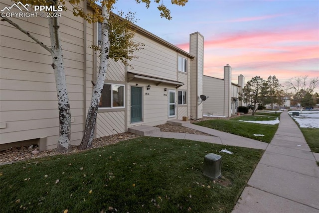 property exterior at dusk with a yard