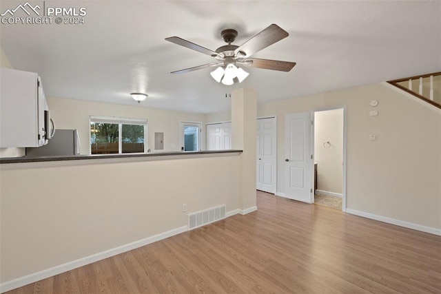 unfurnished living room with ceiling fan and light hardwood / wood-style floors