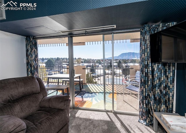 living room featuring carpet flooring, a mountain view, and expansive windows