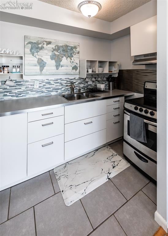 kitchen with tasteful backsplash, white cabinetry, a textured ceiling, and stainless steel electric range