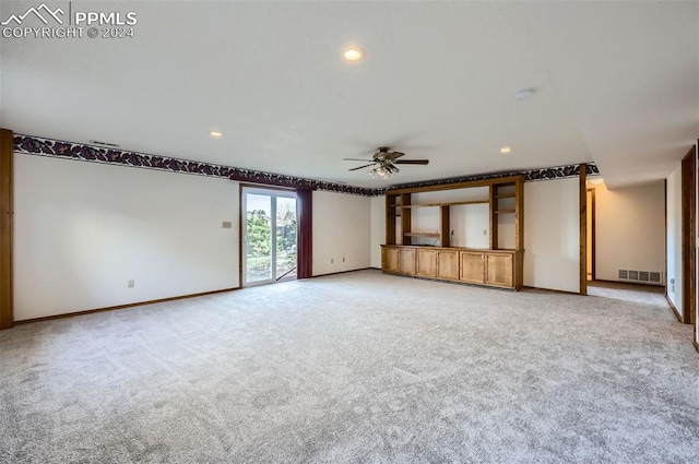 unfurnished living room with ceiling fan and carpet