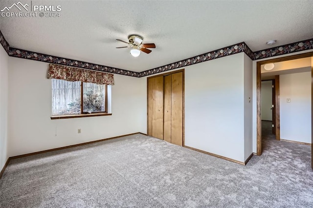 unfurnished bedroom featuring ceiling fan, a closet, carpet, and a textured ceiling