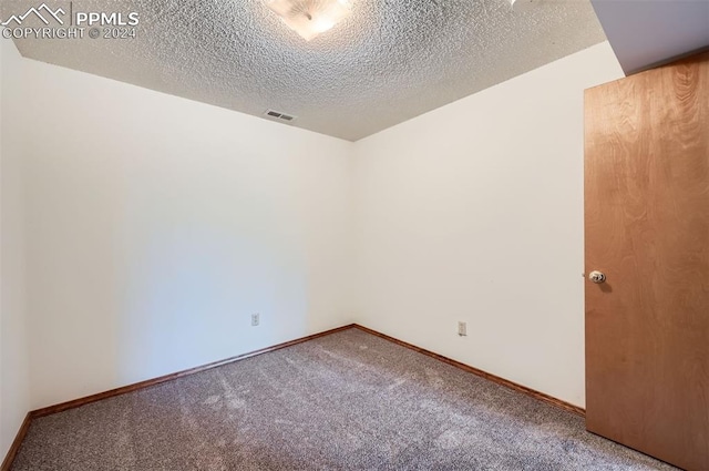 carpeted spare room with a textured ceiling