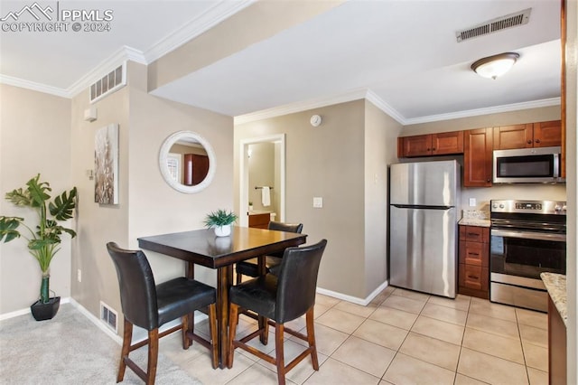 interior space featuring crown molding, light tile patterned floors, light stone countertops, and appliances with stainless steel finishes