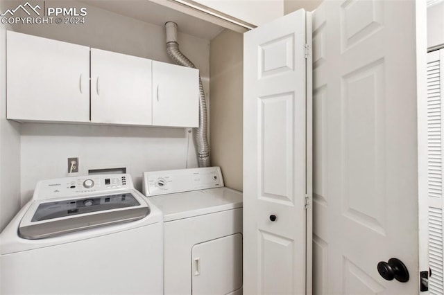 laundry room featuring washer and dryer and cabinets