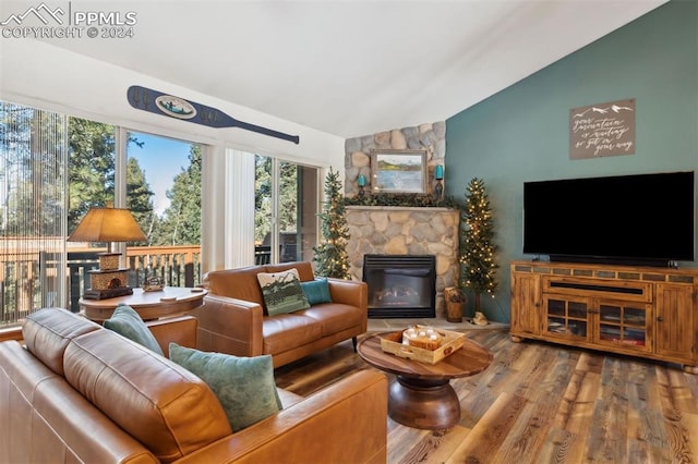 living room with hardwood / wood-style flooring, lofted ceiling, and a fireplace