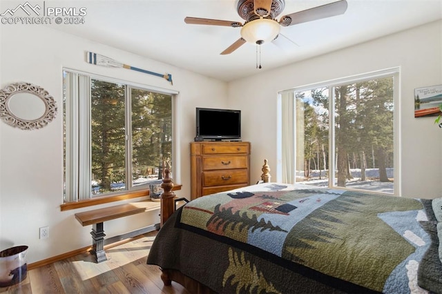 bedroom featuring ceiling fan, light hardwood / wood-style floors, and multiple windows