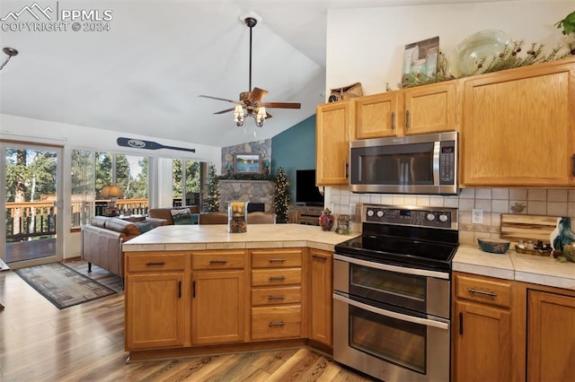 kitchen featuring tasteful backsplash, vaulted ceiling, and appliances with stainless steel finishes