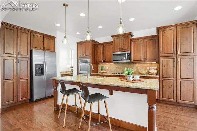2933 Cathedral Park Vw, Colorado Springs, CO 80904 - kitchen featuring appliances with stainless steel finishes, brown cabinetry, wood finished floors, backsplash, and recessed lighting
