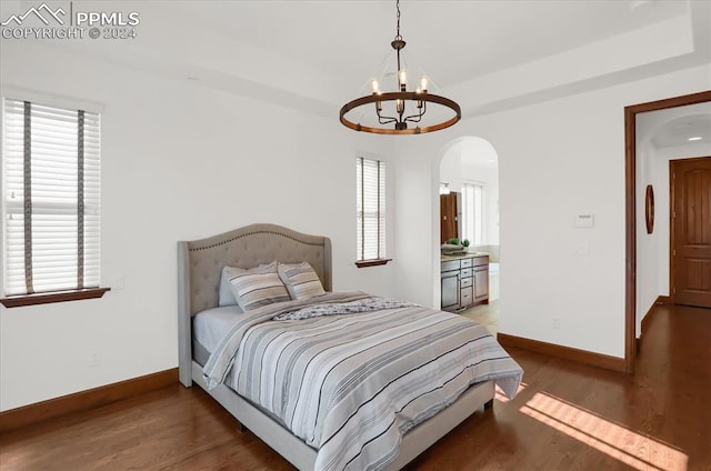 2933 Cathedral Park Vw, Colorado Springs, CO 80904 - bedroom featuring a chandelier, arched walkways, baseboards, and light wood-style floors