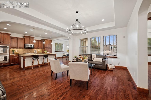 2933 Cathedral Park Vw, Colorado Springs, CO 80904 - living room featuring arched walkways, dark wood-type flooring, a chandelier, baseboards, and recessed lighting
