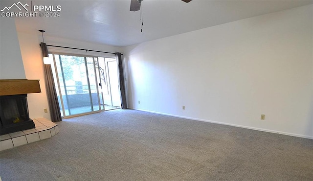 unfurnished living room featuring carpet, ceiling fan, and a tile fireplace