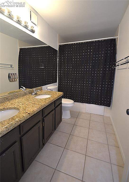 bathroom featuring tile patterned flooring, vanity, and toilet