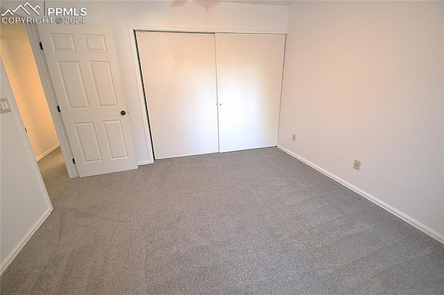 unfurnished bedroom featuring carpet flooring and a closet