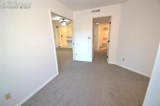 carpeted spare room featuring ceiling fan