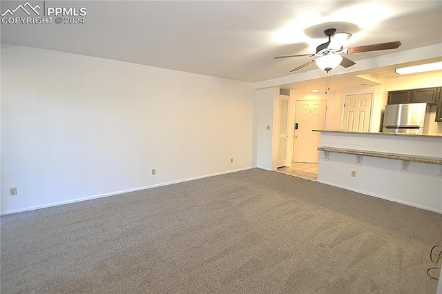 unfurnished living room featuring light colored carpet and ceiling fan