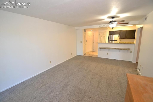 unfurnished living room with ceiling fan and light colored carpet