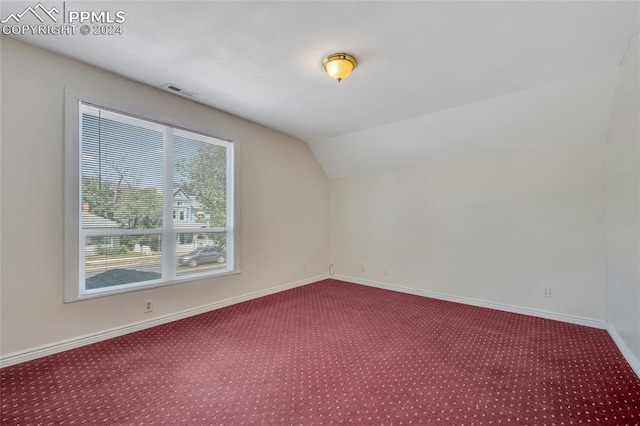 additional living space featuring carpet flooring and lofted ceiling