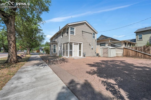 rear view of property featuring a shed