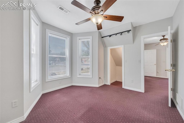 interior space with ceiling fan, carpet floors, and multiple windows