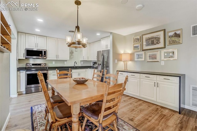 dining room featuring sink and light wood-type flooring