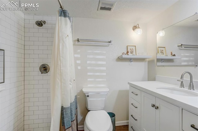 bathroom with a shower with curtain, toilet, a textured ceiling, and vanity