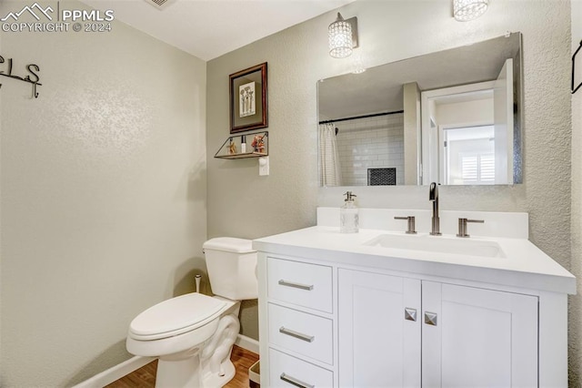 bathroom with curtained shower, hardwood / wood-style floors, vanity, and toilet