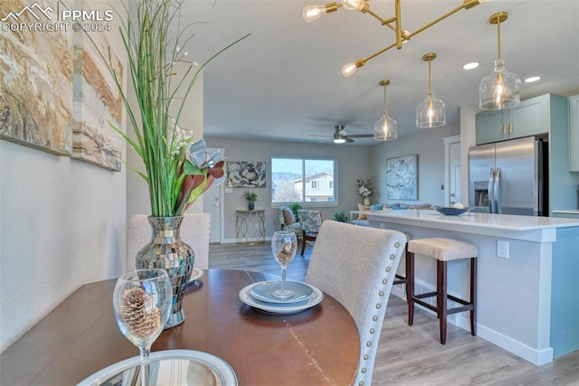 dining space with ceiling fan and light wood-type flooring