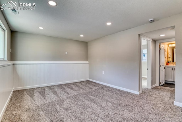 spare room featuring carpet floors and a textured ceiling