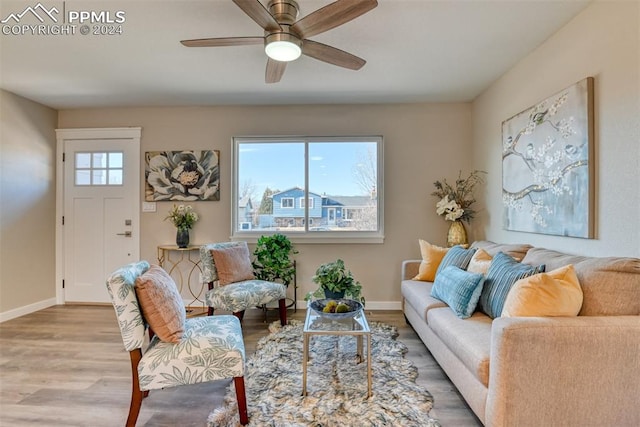 living room with ceiling fan, plenty of natural light, and wood-type flooring