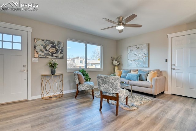 living area with ceiling fan and light hardwood / wood-style flooring