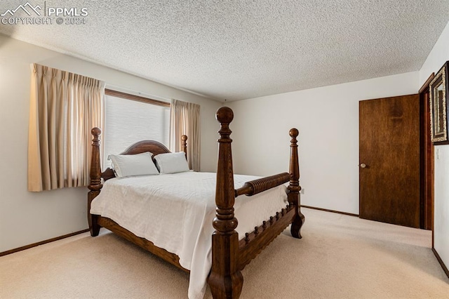 bedroom with light colored carpet and a textured ceiling